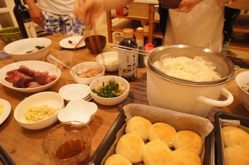 食事会開始です。右手前は焼きたてパンです。忙しい仕事の合間を縫って入居者さんがパン生地を手作りして、その後仕事に戻り、別の入居者さんがパーティ直前にオーブンで焼くという連係プレイでパンを準備してくれました！